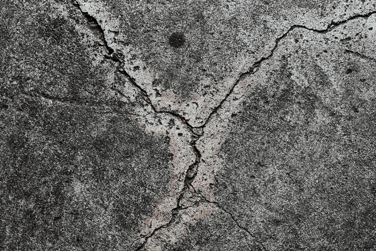Foto de referencia: piso de concreto agrietado y con manchas, típico antes de aplicar un recubrimiento epóxico